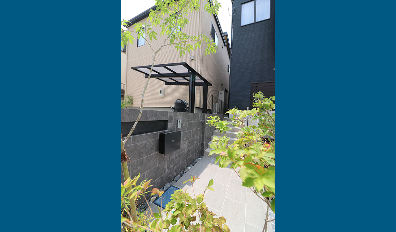 道路からの程よい目隠しも兼ねて配置した高木と、低木・下草をバランスよく配植。足元には割栗石を敷込み