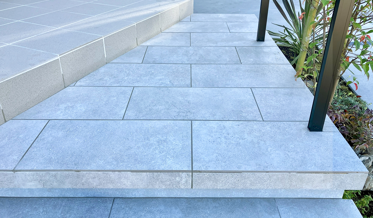 玄関ポーチと色味を合わせた、フローティング階段のタイル