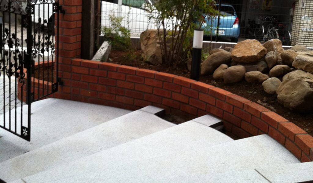 レンガの邸宅と自然石が調和する外構リフォーム