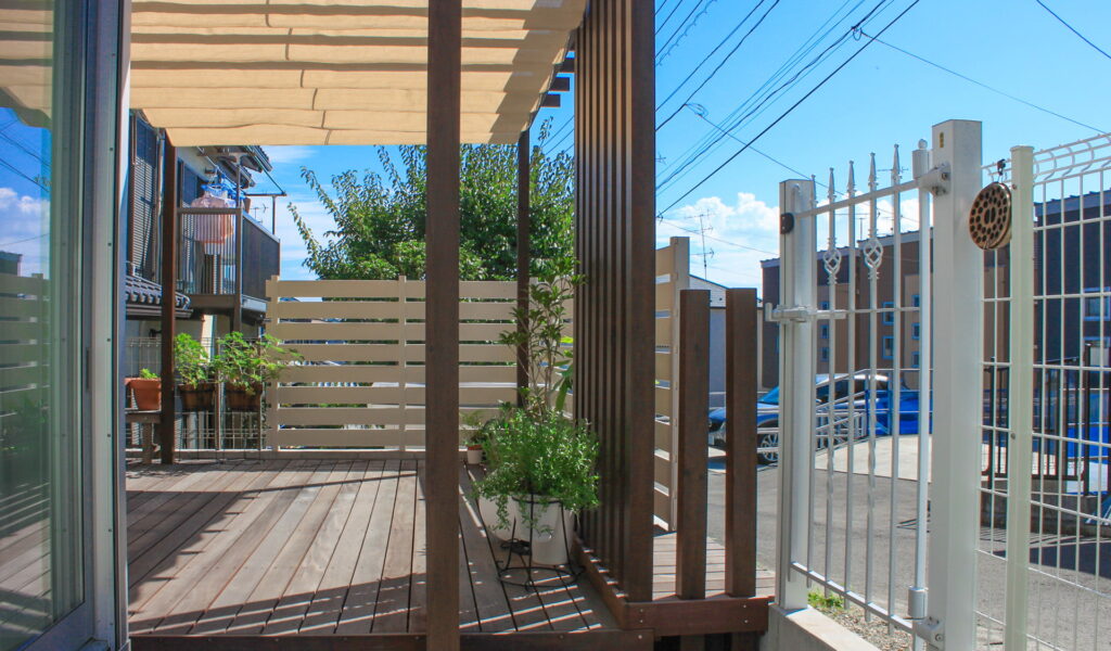 白いパーゴラとフェンスで守るプライバシー重視のウッドデッキテラス