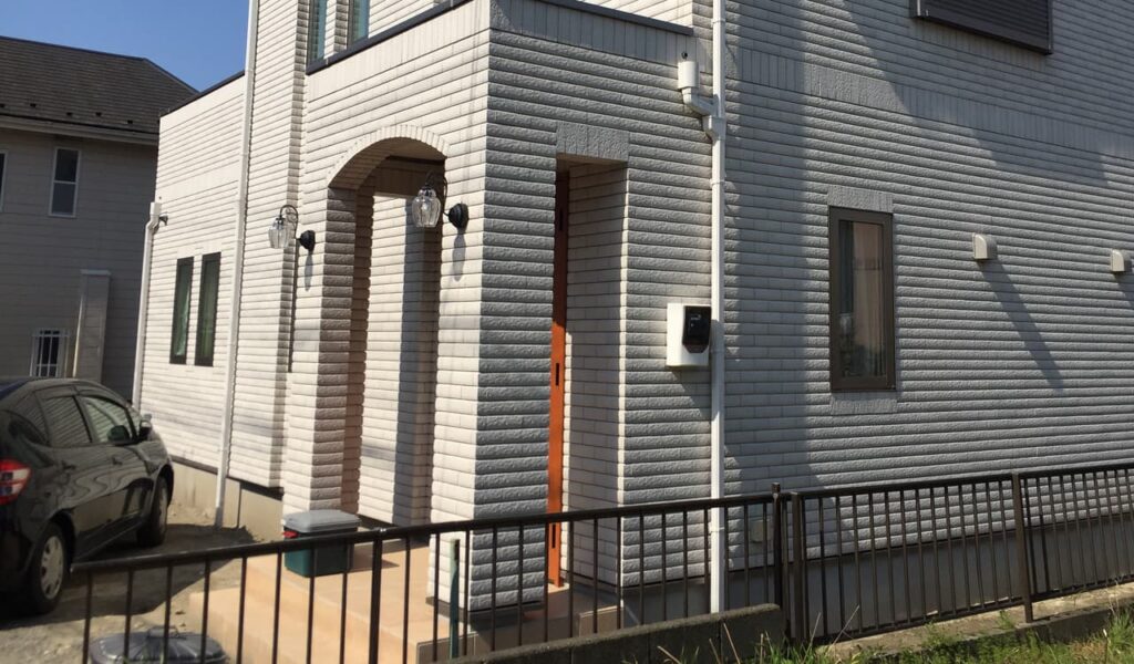 エレガントな白い門袖と枕木のファサード