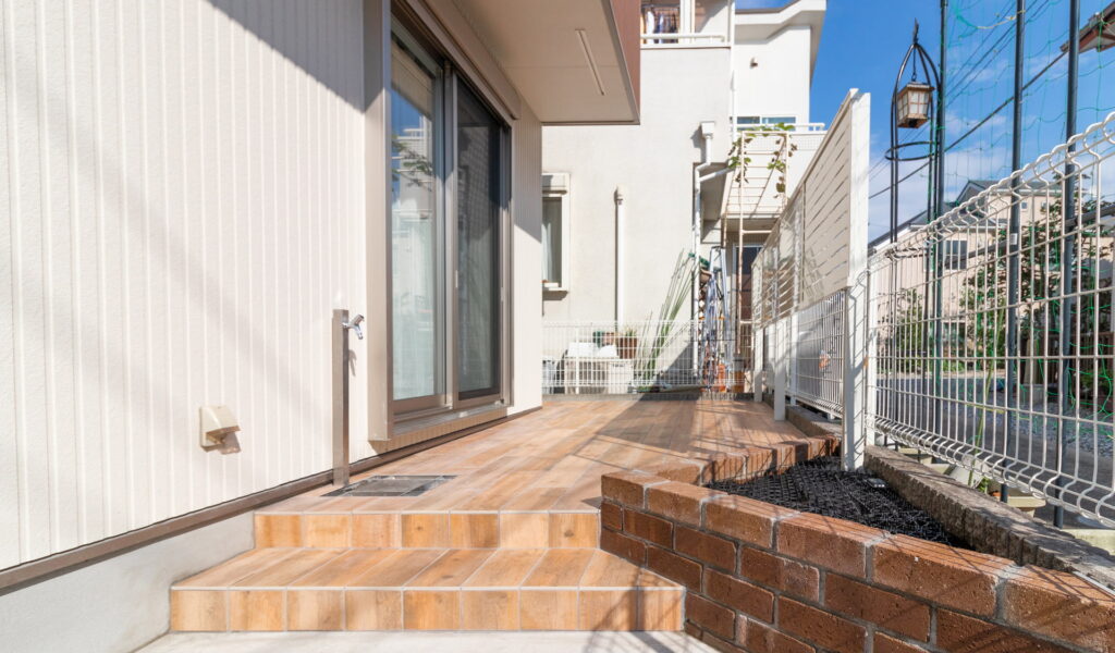 レンガ花壇と木目調タイル貼りのテラス